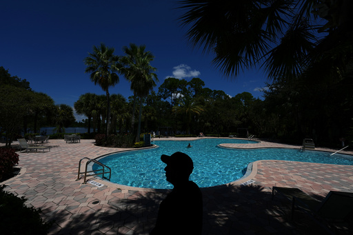 Luis, 30, who fled Venezuela after being an opposition political activist while at university, poses for a picture in the apartment complex where he lives in Orlando, Fla., Tuesday, Aug. 19, 2025. An aspiring entrepreneur with a degree in mechanical engineering, Luis requested asylum in the U.S. and received a work permit which allows him to support himself as an Amazon delivery driver as he goes through the legal asylum process. (AP Photo/Rebecca Blackwell)