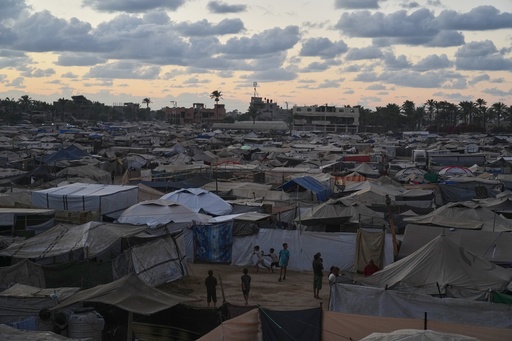 Dusk falls as children play at a temporary tent camp for displaced Palestinians in Deir al-Balah, in the central Gaza Strip, Monday, Oct. 6, 2025. (AP Photo/Abdel Kareem Hana)