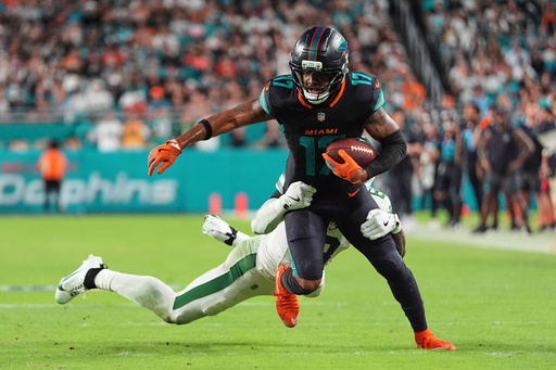 Miami Dolphins wide receiver Jaylen Waddle (17) is tackled by New York Jets safety Andre Cisco (8) in the second half of an NFL football game, Monday, Sept. 29, 2025, in Miami Gardens, Fla. (AP Photo/Rebecca Blackwell)