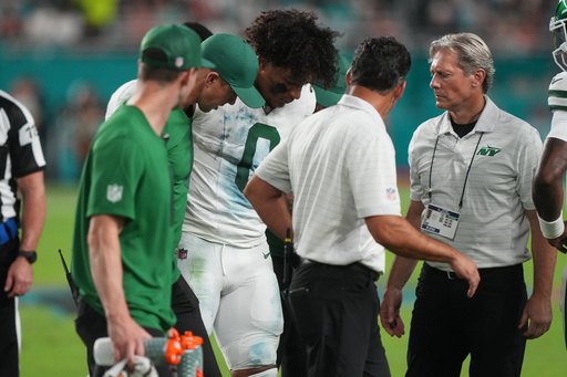 New York Jets running back Braelon Allen (0) walks off the field with team staff after suffering an unknown injury in the first half of an NFL football game against the Miami Dolphins, Monday, Sept. 29, 2025, in Miami Gardens, Fla. (AP Photo/Marta Lavandier)