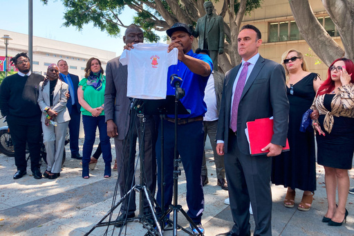 FILE - Jonathan Wright, 39, holds up the T-shirt he was given when he first went to MacLaren Children's Center in El Monte as an 8-year-old during a news conference in Los Angeles, June 9, 2022. (AP Photo/Christopher Weber, File)