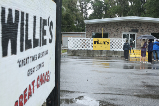 People stand outside of Willie's Bar and Grill in St Helena Island, S.C. after a shooting occurred early Sunday, Oct. 12, 2025. (AP Photo/Lewis M. Levine)