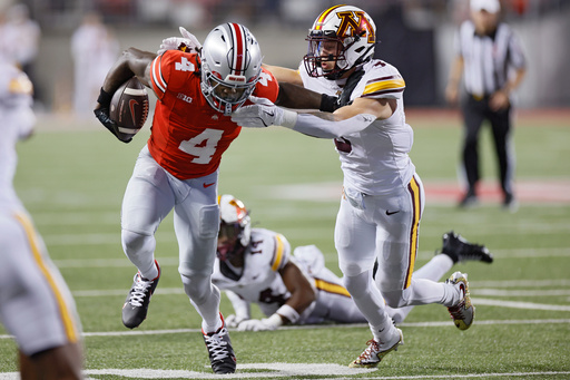 Ohio State receiver Jeremiah Smith, left, stiff arms Minnesota defensive back Koi Perich during the first half of an NCAA college football game Saturday, Oct. 4, 2025, in Columbus, Ohio. (AP Photo/Jay LaPrete)