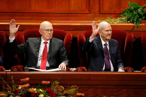 FILE - President Russell M. Nelson, right, raises his hand during a sustaining vote with his counselor, Dallin H. Oaks, left, during The Church of Jesus Christ of Latter-day Saints' twice-annual church conference Oct. 5, 2019, in Salt Lake City. (AP Photo/Rick Bowmer, File)