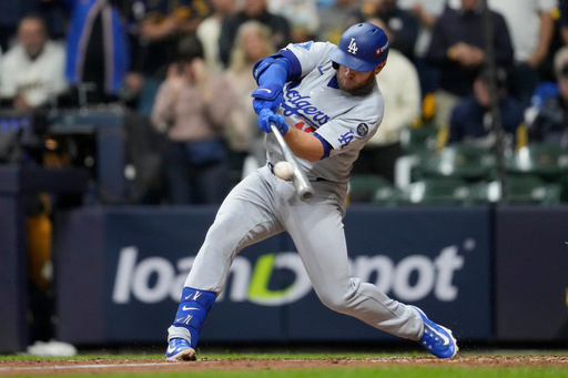 Los Angeles Dodgers' Max Muncy hits a home run against the Milwaukee Brewers during the sixth inning in Game 2 of baseball's National League Championship Series, Tuesday, Oct. 14, 2025, in Milwaukee. (AP Photo/Ashley Landis)