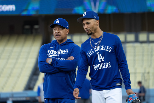 Los Angeles Dodgers manager Dave Roberts, left, talks with Mookie Betts during practice Tuesday, Oct. 7, 2025, in Los Angeles, the day before Game 3 of baseball's National League Division Series against the Philadelphia Phillies. (AP Photo/Jae C. Hong)