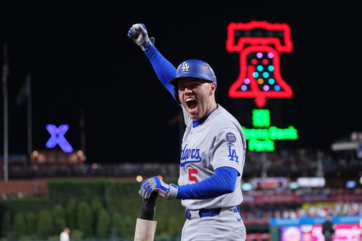 Los Angeles Dodgers' Freddie Freeman reacts after Teoscar Hernández hit a three-run home run off Philadelphia Phillies pitcher Matt Strahm during the seventh inning in Game 1 of baseball's National League Division Series, Saturday, Oct. 4, 2025, in Philadelphia. (AP Photo/Matt Rourke)