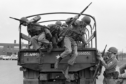 FILE - Tennessee National Guard troops leap out of a truck at the Memphis Armory after being ordered into the city by Gov. Buford Ellington at the request of city officials, March 28, 1968, in Memphis, Tenn. The guard was ordered after rioting and looting erupted midway through a march led by Dr. Martin Luther King Jr. in support of striking garbage workers. (AP Photo/Jack Thornell, File)