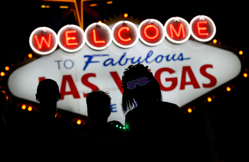 FILE - Runners stop to to have photos taken by official photographers at the Welcome to Las Vegas sign during the Rock 'n' Roll Las Vegas Marathon, Sunday, Nov. 12, 2017, in Las Vegas. (AP Photo/John Locher, File)