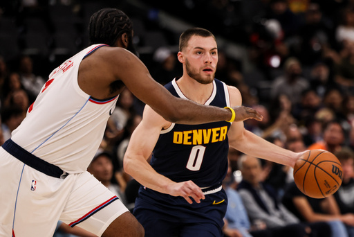 Denver Nuggets guard Christian Braun, right, dribbles past Los Angeles Clippers guard James Harden during the first half of a preseason NBA basketball game, Sunday, Oct. 12, 2025, in Inglewood, Calif. (AP Photo/Etienne Laurent)