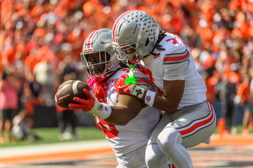 Ohio State defensive lineman Kayden McDonald (98) and cornerback Jermaine Mathews Jr. (7) celebrate a fumble recovery during the first half of an NCAA college football game against Illinois, Saturday, Oct. 11, 2025, in Champaign, Ill. (AP Photo/Craig Pessman)