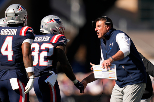 New England Patriots running back TreVeyon Henderson (32) celebrates with head coach Mike Vrabel, right, after scoring a touchdown against the Carolina Panthers during the first half of an NFL football game, Sunday, Sept. 28, 2025, in Foxborough, Mass. (AP Photo/Charles Krupa)
