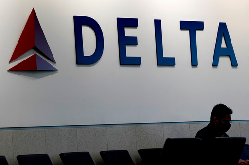 FILE - A man waits for a Delta Airlines flight at Hartsfield-Jackson International Airport in Atlanta on Jan. 7, 2022. (AP Photo/Charlie Riedel, File)