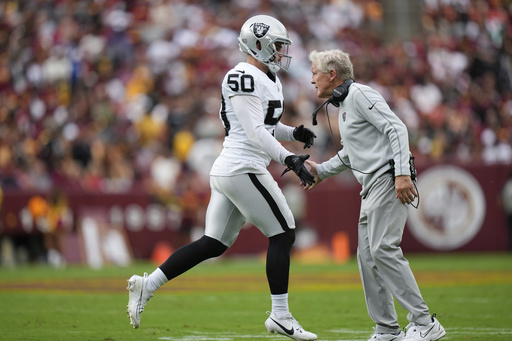 Las Vegas Raiders Pete Carroll shakes hands with long snapper Jacob Bobenmoyer (50) during the first half of NFL football game against the Washington Commanders, Sunday, Sept. 21, 2025, in Landover, Md. (AP Photo/Stephanie Scarbrough)