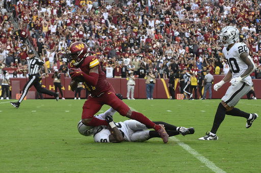 Washington Commanders wide receiver Terry McLaurin (17) is brought down by Las Vegas Raiders cornerback Kyu Blu Kelly (36) during the second half of NFL football game Sunday, Sept. 21, 2025, in Landover, Md. (AP Photo/Nick Wass)
