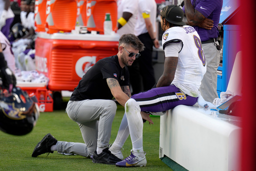 Baltimore Ravens quarterback Lamar Jackson sits on the bench as his leg is worked on during the second half of an NFL football game against the Kansas City Chiefs Sunday, Sept. 28, 2025, in Kansas City, Mo. (AP Photo/Charlie Riedel)