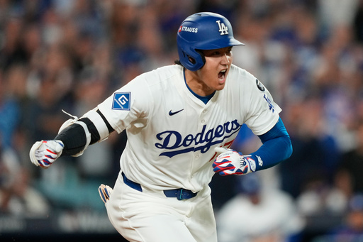 Los Angeles Dodgers' Shohei Ohtani reacts as he drives in a run with a single during the sixth inning in Game 2 of the National League Wild Card baseball playoff series against the Cincinnati Reds, Wednesday, Oct. 1, 2025, in Los Angeles. (AP Photo/Mark J. Terrill)