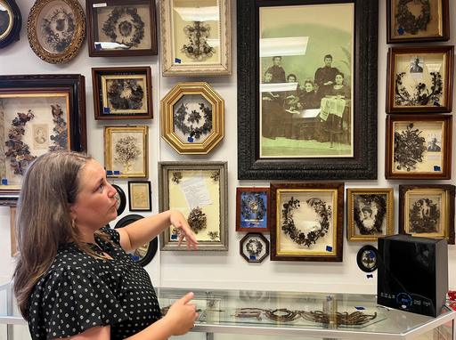 Lindsay Evans gestures to a historic photo of Victorian-era women weaving human hair into art, during a tour of Leila’s Hair Museum on Monday, Oct. 6, 2025, in Independence, Miss. (AP Photo/Heather Hollingsworth)