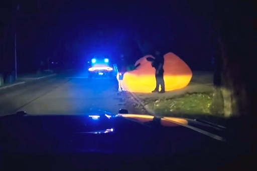 This image made from a Parma Heights Police Department body camera video shows a police officer approaching a runaway inflatable pumpkin on Tuesday, Oct. 7, 2025. (Parma Heights Police Department via AP)