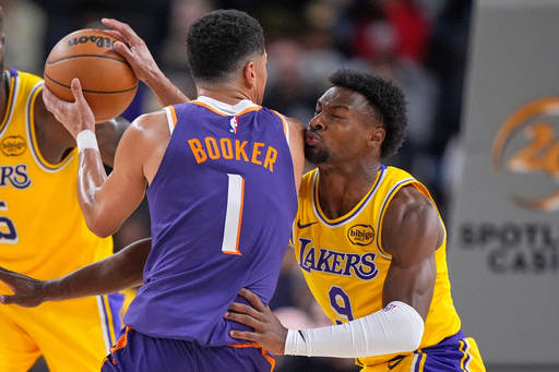 Phoenix Suns guard Devin Booker, left, tries to get by Los Angeles Lakers guard Bronny James during the first half of an NBA preseason basketball game Friday, Oct. 3, 2025, in Palm Desert, Calif. (AP Photo/Mark J. Terrill)