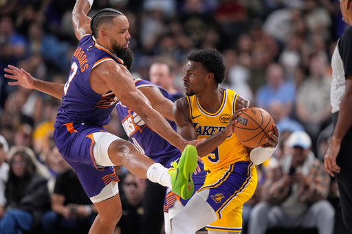 Los Angeles Lakers guard Bronny James, right, tries to pass while under pressure from Phoenix Suns forward Dillon Brooks during the second half of an NBA preseason basketball game Friday, Oct. 3, 2025, in Palm Desert, Calif. (AP Photo/Mark J. Terrill)