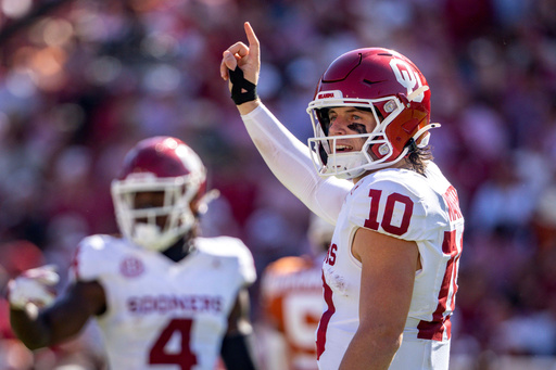 Oklahoma quarterback John Mateer signals to the sideline during the first half of an NCAA college football game against Texas, Saturday, Oct. 11, 2025, in Dallas. (AP Photo/Jeffrey McWhorter)