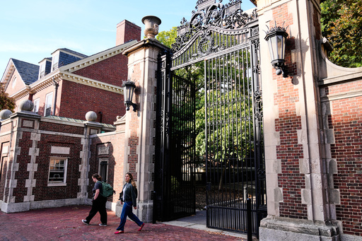 Two women walk through a gate from Harvard Yard at Harvard University, Tuesday, Sept. 30, 2025, in Cambridge, Mass. (AP Photo/Charles Krupa)
