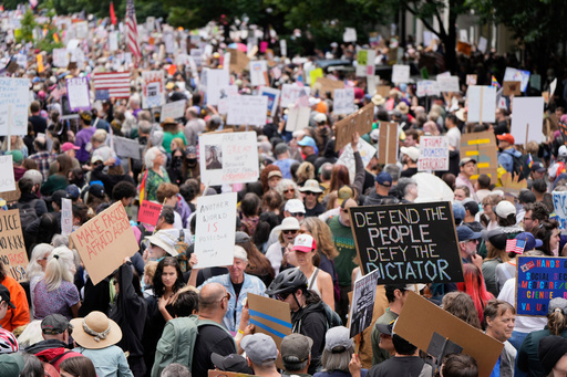 FILE - Demonstrators take part in the "No Kings" protest, June 14, 2025, in Portland, Ore. (AP Photo/Jenny Kane, File)