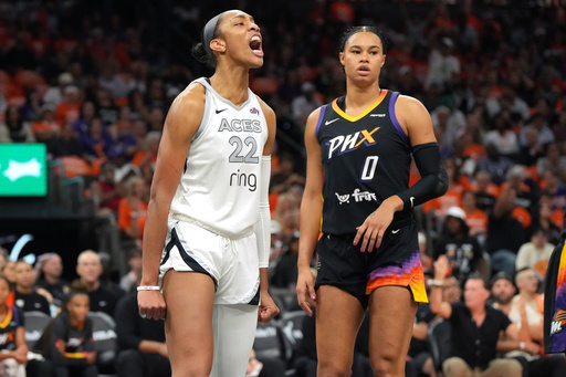Las Vegas Aces center A'ja Wilson (22) reacts after scoring on Phoenix Mercury forward Satou Sabally during the first half of Game 3 of the WNBA basketball finals, Wednesday, Oct. 8, 2025, in Phoenix. (AP Photo/Rick Scuteri)
