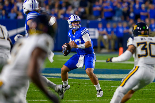 BYU quarterback Bear Bachmeier, center, looks to pass the ball during the first half of an NCAA college football game against West Virginia, Friday, Oct. 3, 2025, in Provo, Utah. (AP Photo/Tyler Tate)
