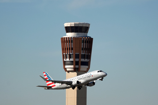 An American Airlines American Eagle jet flies past the air traffic control tower at Phoenix Sky Harbor International Airport Saturday, Nov. 8, 2025, in Phoenix. (AP Photo/Ross D. Franklin)