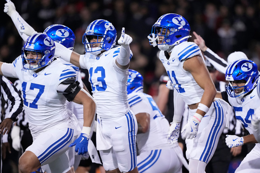 From left, BYU linebacker Jack Kelly (17), defensive lineman Tausili Akana (13), safety Faletau Satuala (11) and linebacker Siale Esera (54) celebrate as they run off the field after a turn over on downs during the first half of an NCAA college football game against Cincinnati, Saturday, Nov. 22, 2025, in Cincinnati. (AP Photo/Carolyn Kaster)