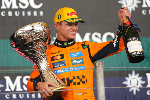 McLaren driver Lando Norris of Britain celebrates on the podium his first place in the Brazilian Formula One Grand Prix at the Interlagos race track in Sao Paulo, Sunday, Nov. 9, 2025. (AP Photo/Andre Penner)