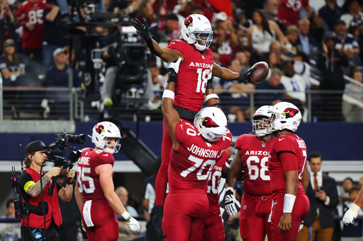 Arizona Cardinals wide receiver Marvin Harrison Jr. (18) is lifted by Paris Johnson Jr. (70) as the two and others celebrate Harrison Jr.s' touchdown catch in the first half of an NFL football game against the Dallas Cowboys Monday, Nov. 3, 2025, in Arlington, Texas. (AP Photo/Richard Rodriguez)