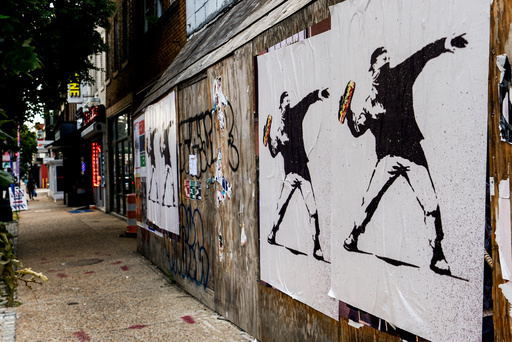 FILE - Posters of a person throwing a sandwich are pictured along H Street, Aug. 17, 2025, in Washington. (AP Photo/Julia Demaree Nikhinson, File)