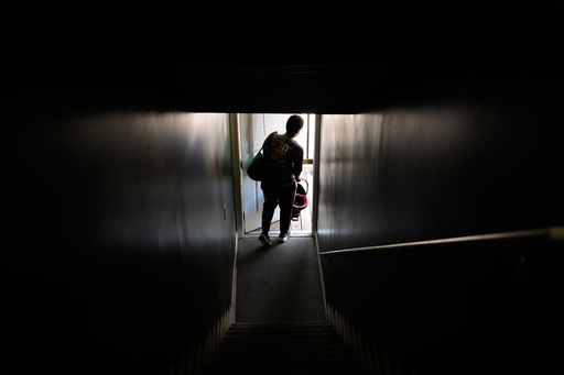 Sechita McNair walks out of a new Atlanta apartment with cleaning supplies on Friday, Aug. 1, 2025. (AP Photo/Brynn Anderson)
