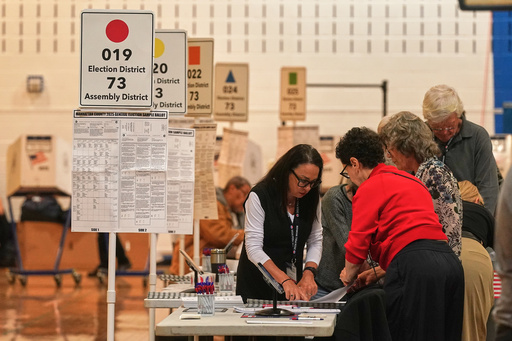 Workers prepare for voters at a poll site, in New York, Tuesday, Nov. 4, 2025. (AP Photo/Richard Drew)