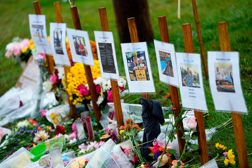 FILE — Rain soaked memorials for those who died in a mass shooting sit along the roadside by Schemengees Bar & Grille, Oct. 30, 2023, in Lewiston, Maine. (AP Photo/Matt York, File)