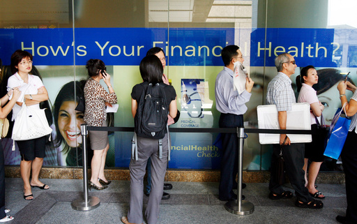 FILE -Customers of American International Assurance (AIA), a wholly owned subsidiary of American Insurance Group (AIG) stand in line outside the AIA office as they wait to speak to customer service officers, and some others seeking advice on terminating their insurance policies on Tuesday Sept. 16, 2008 in Singapore amid fears that that American Insurance Group, the world's largest insurer, was fighting for its survival after downgrades from major credit rating firms, adding pressure as AIG seeks billions of dollars to strengthen its balance sheet.(AP Photo/Wong Maye-E, File)