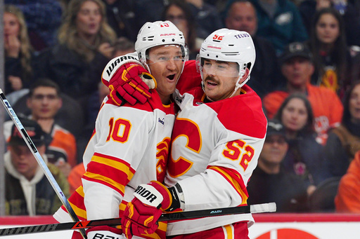 Calgary Flames' Jonathan Huberdeau, left, celebrates after his goal with Mackenzie Weegar (52) during the third period of an NHL hockey game against the Philadelphia Flyers, Sunday, Nov. 2, 2025, in Philadelphia. (AP Photo/Derik Hamilton)
