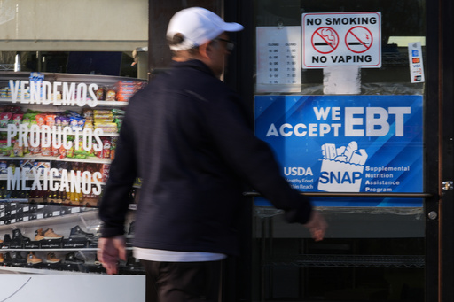 A customer walks into a bakery as a SNAP EBT information sign is displayed at the front door in Chicago, Sunday, Nov. 2, 2025. (AP Photo/Nam Y. Huh)