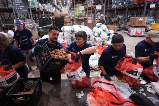 Volunteers at the San Antonio Food Bank load bags of potatoes for a food distribution for SNAP recipients and other households affected by the federal shutdown, Thursday, Nov. 6, 2025, in San Antonio. (AP Photo/Eric Gay)
