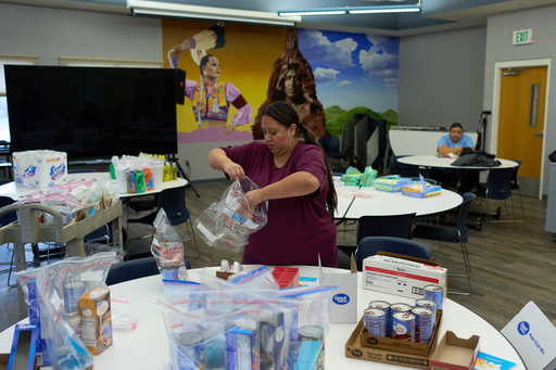 Carla Teran helps prepare bagged meals for a food bank for students at Nueta Hidatsa Sahnish College, Thursday, Oct. 30, 2025, in New Town, N.D. (AP Photo/John Locher)