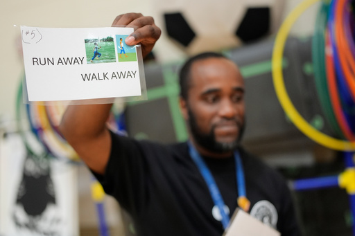 Health and physical education teacher Ronald Anderson holds instructions for students when they encounter a firearm during a gun safety lesson at Berclari Elementary School, Monday, Oct. 27, 2025, in Memphis, Tenn. (AP Photo/George Walker IV)