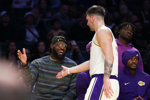Los Angeles Lakers forward LeBron James, left, and guard Luka Doncic, center, celebrate as forward Jarred Vanderbilt, right, looks on during the second half of an NBA basketball game against the Miami Heat, Sunday, Nov. 2, 2025, in Los Angeles. (AP Photo/Jessie Alcheh)