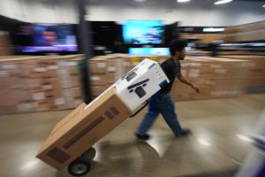A Best Buy employee hauls early Black Friday sale items at Best Buy Thursday, Nov. 20, 2025, in San Diego. (AP Photo/Gregory Bull)