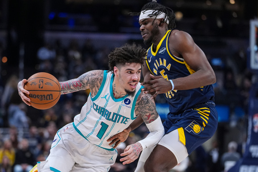 Charlotte Hornets guard Lamelo Ball (1) drives on Indiana Pacers forward Jarace Walker (5) during the first half of an NBA basketball game in Indianapolis, Wednesday, Nov. 19, 2025. (AP Photo/Michael Conroy)