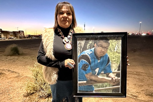 Vangie Randall-Shorty holds up a photograph of her son Zachariah Shorty during a stop in Bernalillo, N.M., Nov. 24, 2025. (AP Photo/Susan Montoya Bryan)