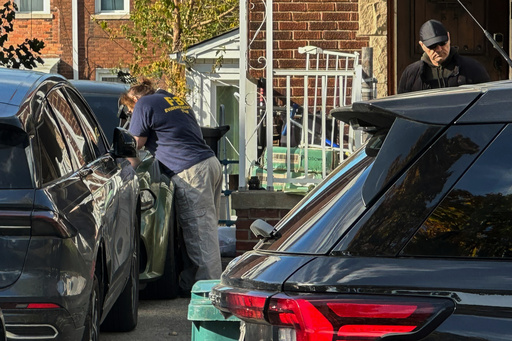 FBI agents gather outside a home in a Dearborn, Mich., neighborhood on Friday, Oct. 31, 2025. (AP Photo/Mike Householder)