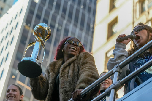 Gotham Football Club captain Mandy Freeman holds up the NWSL championship trophy as she rides down Broadway with the team during a parade celebrating their win over the Washington Spirit, Monday, Nov. 24, 2025, in New York. (Michael Appleton/New York City Mayor's Office via AP)